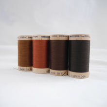 Load image into Gallery viewer, Four wooden reels of organic cotton sewing thread in Acorn Brown, Copper, Mid Brown and Dark Brown colours

