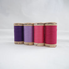 Load image into Gallery viewer, Four reels of organic cotton sewing thread in Purple, Lavender, Bubblegum and Fuchsia colours.
