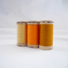 Load image into Gallery viewer, Wooden reels of organic cotton sewing thread in Straw, Tangerine and Gold Ochre colours

