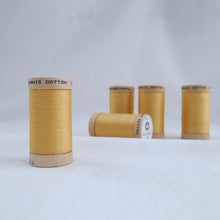 Load image into Gallery viewer, Five reels of Scanfil Organic Cotton Thread in Straw, a light mustard colour.
