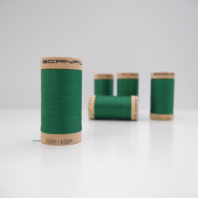 Four wooden reels of Organic Cotton Sewing Thread on table
