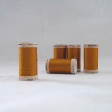 Load image into Gallery viewer, Five wooden reels of organic sewing cotton thread in a gold ochre colour

