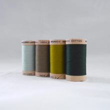 Load image into Gallery viewer, Four wooden reels of organic cotton sewing threads in mint, khaki, celery and forest green colours.
