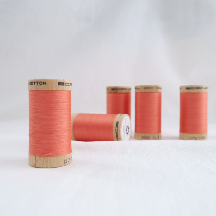 Five wooden reels of Scanfil Organic Cotton Thread in Salmon