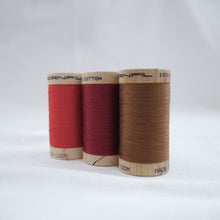 Load image into Gallery viewer, Three wooden reels of Scanfil Organic Cotton Thread in Ruby Red, Wine and Acorn Brown colours.
