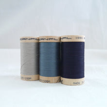 Load image into Gallery viewer, Three wooden reels of a grey, a dusky blue, and a dark navy blue.
