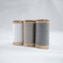 Load image into Gallery viewer, Three wooden reels of Scanfil Organic Cotton Thread in White, Sand and Steel Grey colours.
