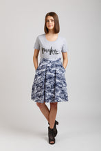 Load image into Gallery viewer, Front view of knee-length culottes in patttern fabric, posing with hands in pockets
