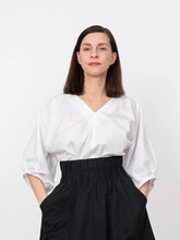Load image into Gallery viewer, Lady wears a V-Neck Cuff Top tucked into skirt, with gathered sleeves

