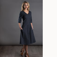 Load image into Gallery viewer, Lady wears V-neck dress with A-line skirt. Hands in pockets
