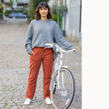 Load image into Gallery viewer, Lady stands next to bike wearing The City Trousers, a slim leg with hand in pocket
