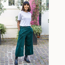 Load image into Gallery viewer, Lady wears The Culottes with hands in pockets, shows pleats at waistline
