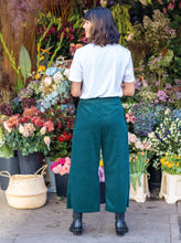 Load image into Gallery viewer, Back view of lady wearing The Culottes in front of a flower stall 
