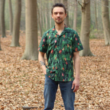 Load image into Gallery viewer, Man stands wearing Tropical short-sleeve shirt with one chest pocket in a green leaf pattern fabric.
