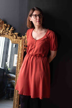 Load image into Gallery viewer, Lady stands next to a mirror wearing a collared dress made with Dottie Terracotta Viscose fabric
