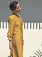 Load image into Gallery viewer, Side view of lady wearing Zenith dress highlights the puffy  three quarter length sleeves.
