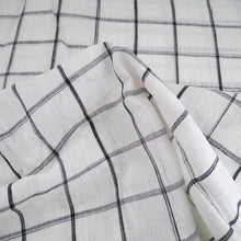 Load image into Gallery viewer, White and black box check pattern linen fabric scrunched to show crisp and sheerness
