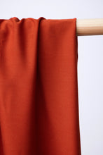Load image into Gallery viewer, Close up of EcoVero Viscose fabric hangs and drapes over a wooden pole shows twill weave
