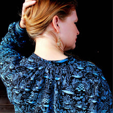 Load image into Gallery viewer, Back view of lady wearing Sille Shirt holds up her hair to show off gathers at collar stand neckline.
